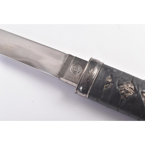 203 - A vintage Japanese Samurai Tanto knife with a plaited leather grip, metal fittings in the form of dr... 