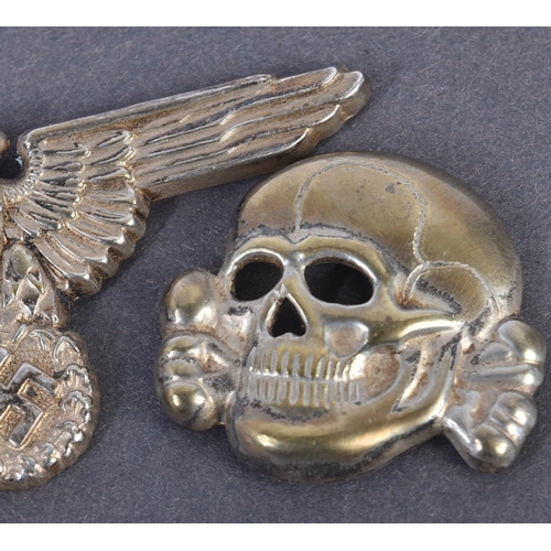 313 - Two WWII Second World War style Third Reich Nazi German cap badges comprising an SS skull and cross ... 