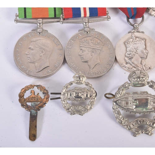 397 - A WWII Second World War medal group and a selection of cap badges comprising Royal Tank Regiment and... 