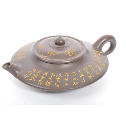 117 - A pair of 20th century Chinese terracotta teapots to include a squat example with engraved script to... 