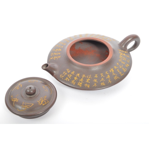 117 - A pair of 20th century Chinese terracotta teapots to include a squat example with engraved script to... 