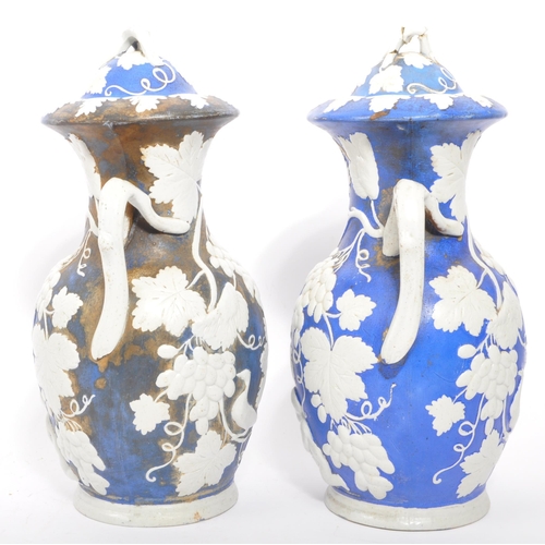 173 - A pair of 19th century Victorian ceramic pottery blue and white lidded vases. With twin handles whit... 