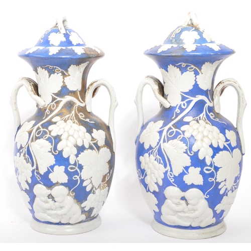 173 - A pair of 19th century Victorian ceramic pottery blue and white lidded vases. With twin handles whit... 