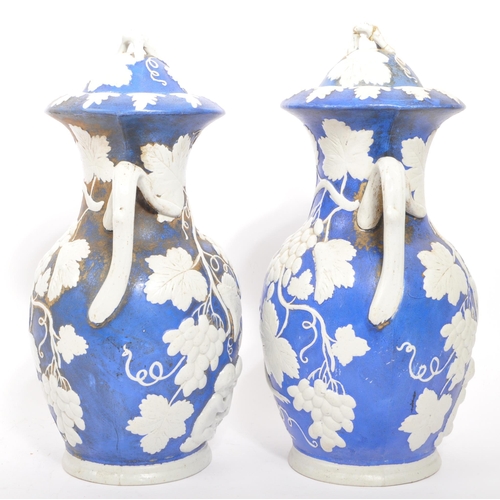 173 - A pair of 19th century Victorian ceramic pottery blue and white lidded vases. With twin handles whit... 