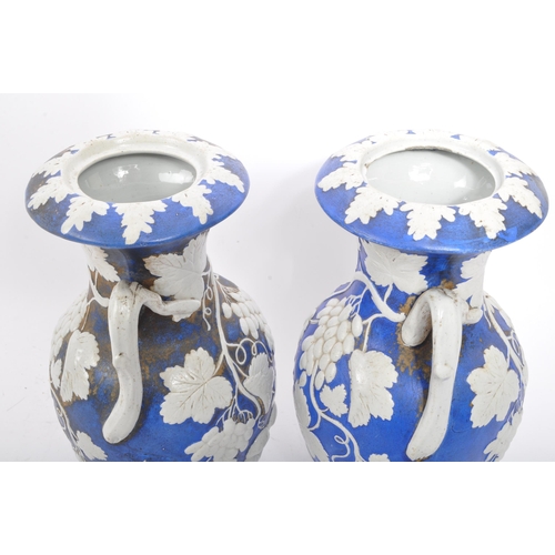 173 - A pair of 19th century Victorian ceramic pottery blue and white lidded vases. With twin handles whit... 