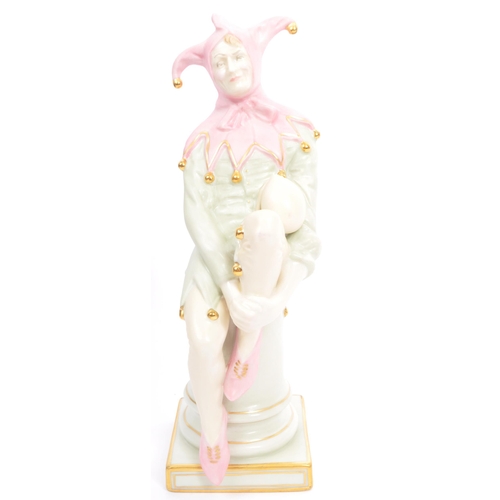 189 - A Royal Doulton table top porcelain china figurine of 'The Jester'. HN3922. In a seated position on ... 