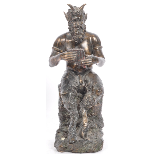 240 - A cast faux bronze classical figurine sculptural ornament in the from of a faun / satyr holding a se... 