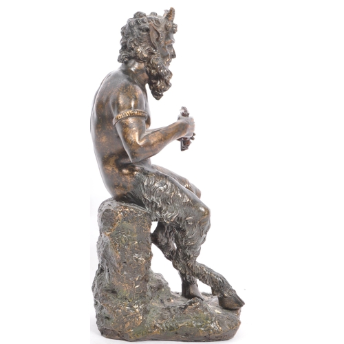 240 - A cast faux bronze classical figurine sculptural ornament in the from of a faun / satyr holding a se... 