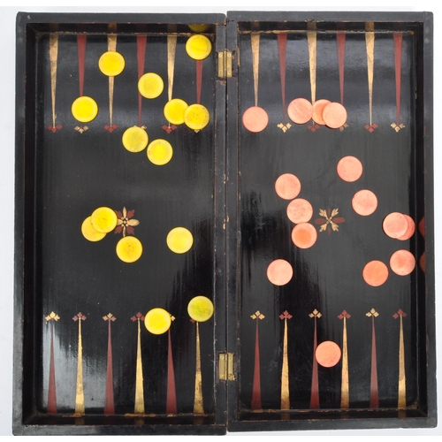 242 - A vintage 19th century folding chessboard/backgammon set. In ebonised wood with gilded detailing aro... 