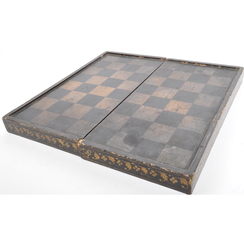 242 - A vintage 19th century folding chessboard/backgammon set. In ebonised wood with gilded detailing aro... 