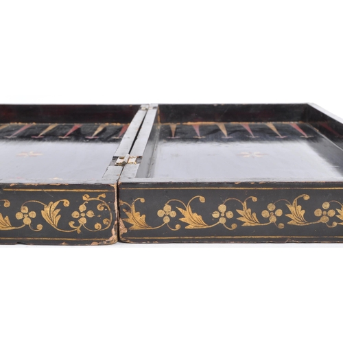 242 - A vintage 19th century folding chessboard/backgammon set. In ebonised wood with gilded detailing aro... 