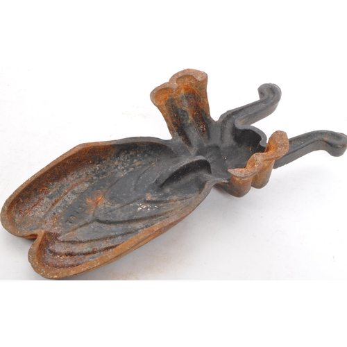 243 - A vintage 20th Century cast iron boot remover in the form of a Beetle. Reg number to the verso Measu... 