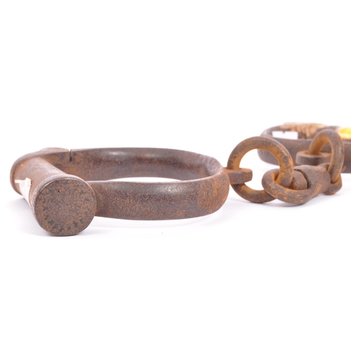 250 - An early 19th century pair of cast iron handcuffs. Stamped Hiatt 3 / 130, M&C 1916. Probably Police ... 