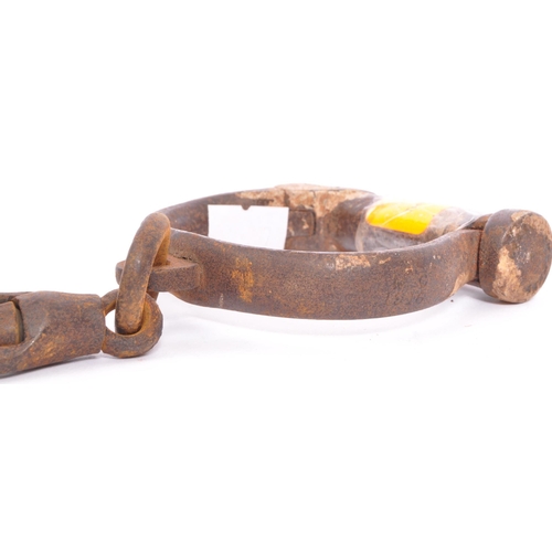 250 - An early 19th century pair of cast iron handcuffs. Stamped Hiatt 3 / 130, M&C 1916. Probably Police ... 