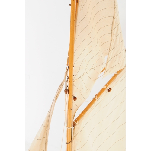 257 - A 20th century wooden scratch built pond yacht model boat with twin sail and accompanying stand.