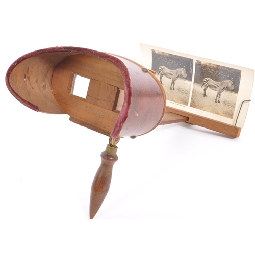 272 - An early 20th century stereo card viewer with a brass and wooden handle together with stereo cards d... 