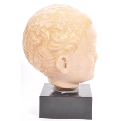 292 - A 20th century resin bust modelled in the form of a young boy raised upon square black marble base.