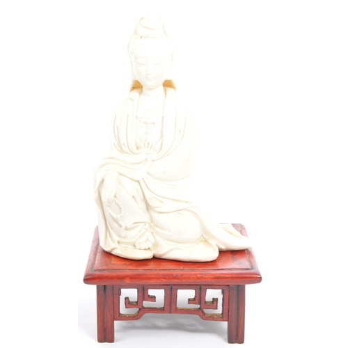 295 - A 20th century Chinese bisque porcelain female GuanyinÂ Bodhisattva figure upon a Chinese pierced so... 