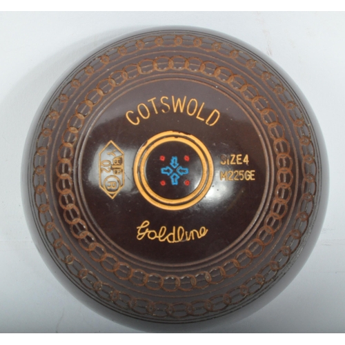 328 - A 20th Century Cotswold Goldline lawn bowls. Having four bowls, size four in a brown colourway with ... 