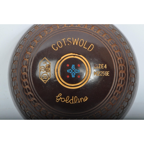 328 - A 20th Century Cotswold Goldline lawn bowls. Having four bowls, size four in a brown colourway with ... 