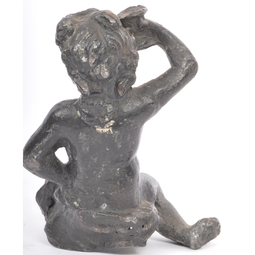 330 - An early 20th lead sculpture in the form of a putti robed and seated with arm raised. Measures 15cm ... 