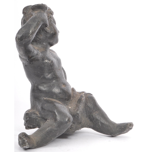 330 - An early 20th lead sculpture in the form of a putti robed and seated with arm raised. Measures 15cm ... 