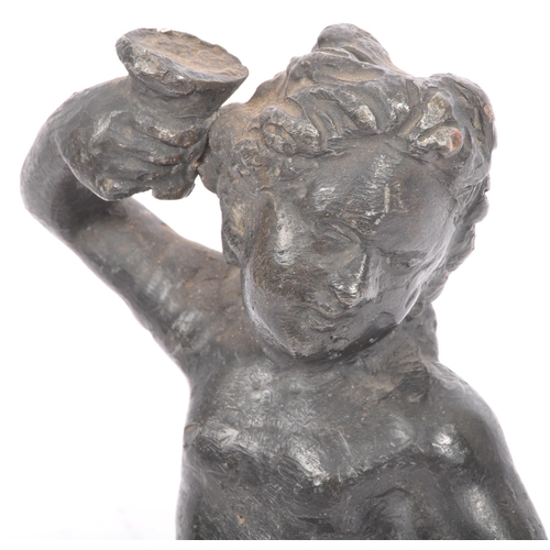 330 - An early 20th lead sculpture in the form of a putti robed and seated with arm raised. Measures 15cm ... 