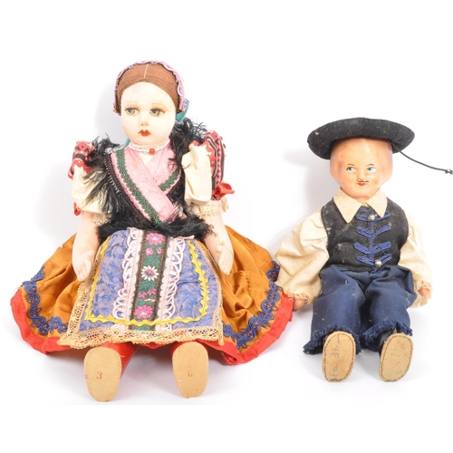 336 - Two vintage dolls comprising a European folk inspired cloth body doll with painted face wearing a tr... 