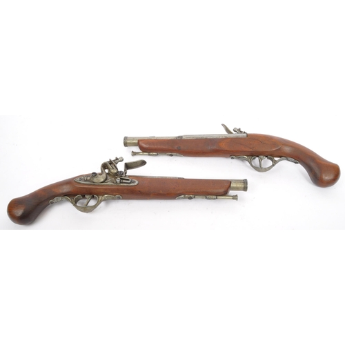 350 - A pair of replica reproduction flintlock wall mountable decorative 18th century pistols. Of wood and... 