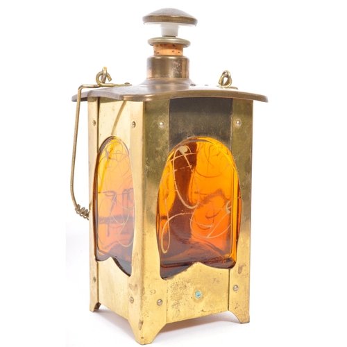 356 - An Arts & Craft brass lantern drinking decanter music box. With stopper and pourer to top, square fo... 