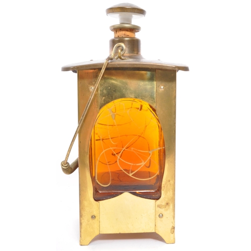 356 - An Arts & Craft brass lantern drinking decanter music box. With stopper and pourer to top, square fo... 