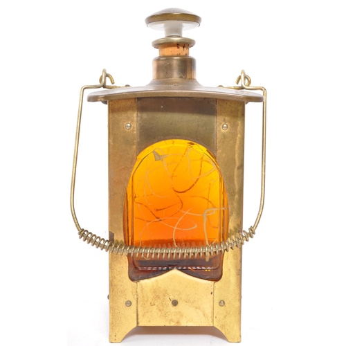 356 - An Arts & Craft brass lantern drinking decanter music box. With stopper and pourer to top, square fo... 