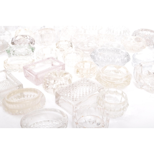 78 - A large collection of 20th century cut glass and pressed glass salts in a variety of shapes.