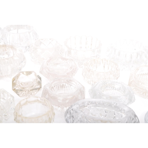 78 - A large collection of 20th century cut glass and pressed glass salts in a variety of shapes.