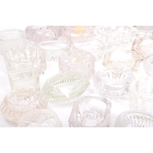 78 - A large collection of 20th century cut glass and pressed glass salts in a variety of shapes.