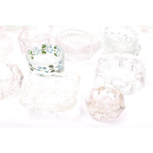 78 - A large collection of 20th century cut glass and pressed glass salts in a variety of shapes.