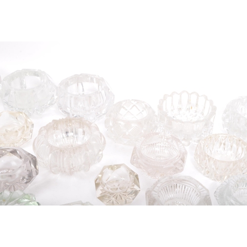 78 - A large collection of 20th century cut glass and pressed glass salts in a variety of shapes.