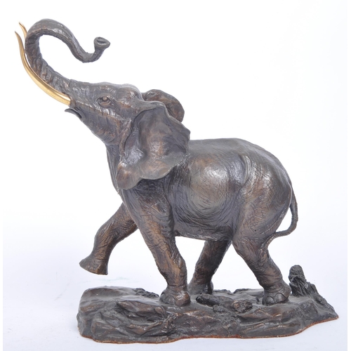 23 - A 20th century patinated bronze elephant being set with gilt brass tusks and raised over a naturalis... 