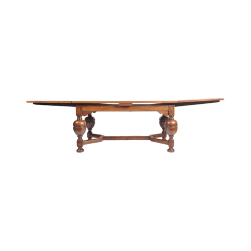 27 - An early 20th century large oak and parquetry draw leaf refectory dining table in the manner of Rube... 