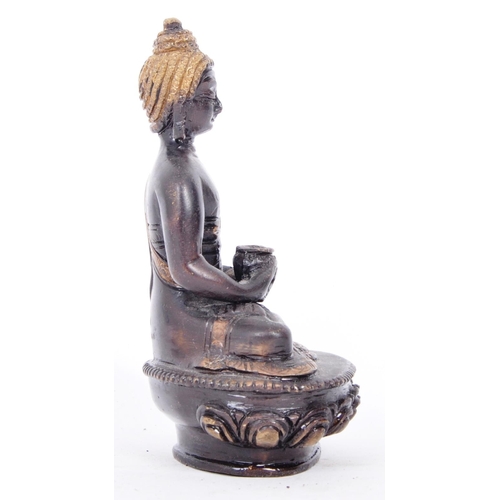 37 - An early 20th century Chinese two tone bronze figurine depicting Buddha. The figure having a blacken... 