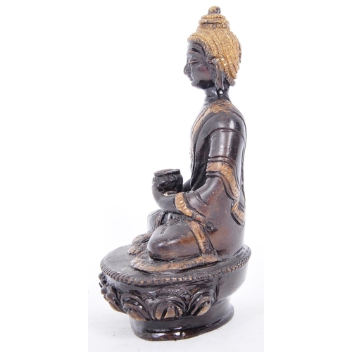 37 - An early 20th century Chinese two tone bronze figurine depicting Buddha. The figure having a blacken... 
