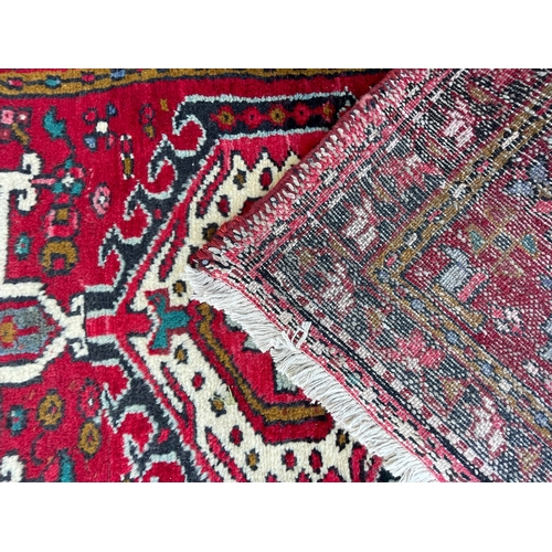 64 - An early 20th century North West Persian Islamic Heriz hand woven floor carpet runner rug having a c... 