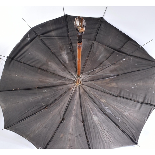 370 - A 19th Century French self defence umbrella with concealed blade. The umbrella with a carved rhino h... 