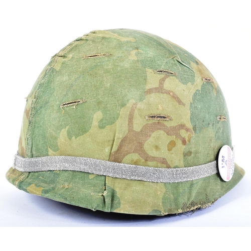 79 - A Vietnam War Era US United States M1 steel combat helmet with reversible camo cover. The swivel bal... 