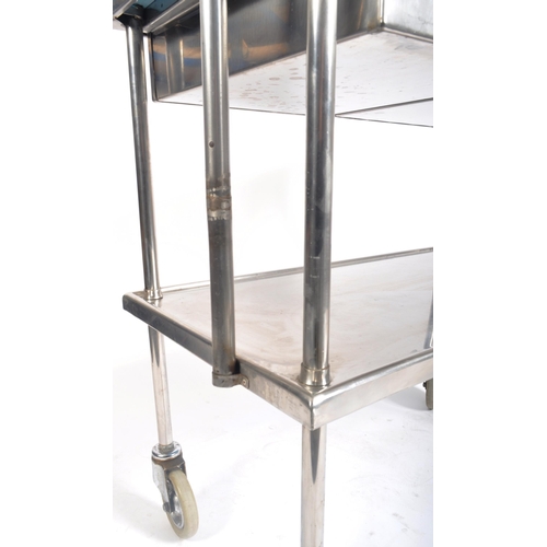 148 - A contemporary medical / industrial three tier stainless steel trolley, having twin drawer fitted fr... 