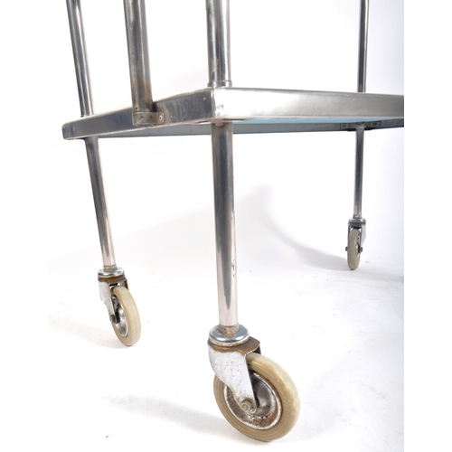 148 - A contemporary medical / industrial three tier stainless steel trolley, having twin drawer fitted fr... 