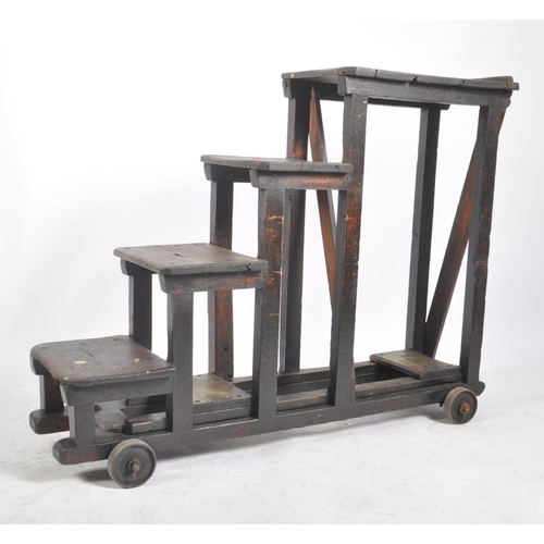 201 - A large early 20th century stained pine wood industrial railway / mill steps ladder on wheels. The t... 