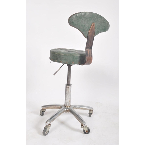 72 - A 20th century industrial / factory workmen's swivel office desk chair having a shaped green leather... 