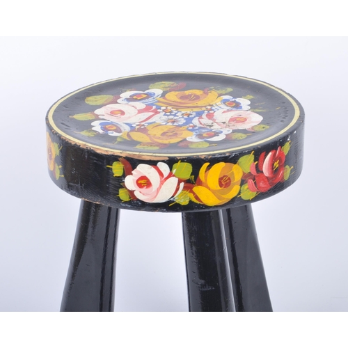 77 - A 20th century painted wood bargeware style low stool. The stool having a circular top over tripod i... 