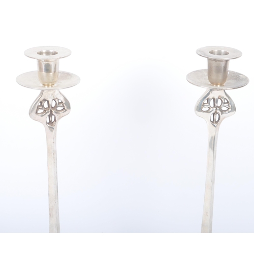 83 - A pair of c1920s Art Nouveau silver coloured white metal candle stick holders of naturalistic column... 